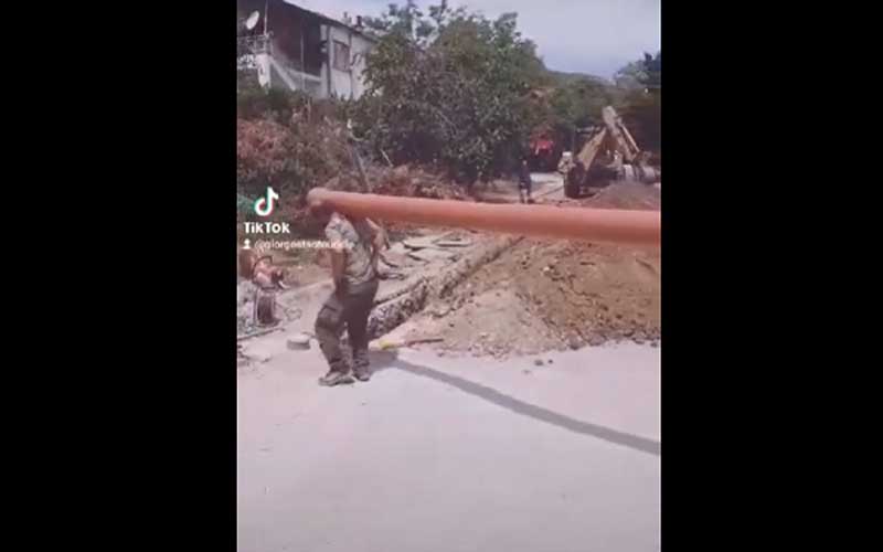 Υπάλληλοι της ΔΕΥΑ Καστοριάς μεταφέρουν ένα σωλήνα χορεύοντας